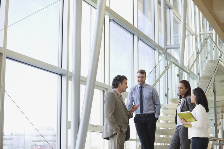 Business colleagues talking while standing by stairway