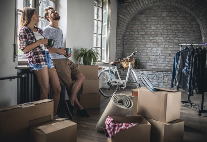 Young cheerful couple communicating after relocating into new apartment.